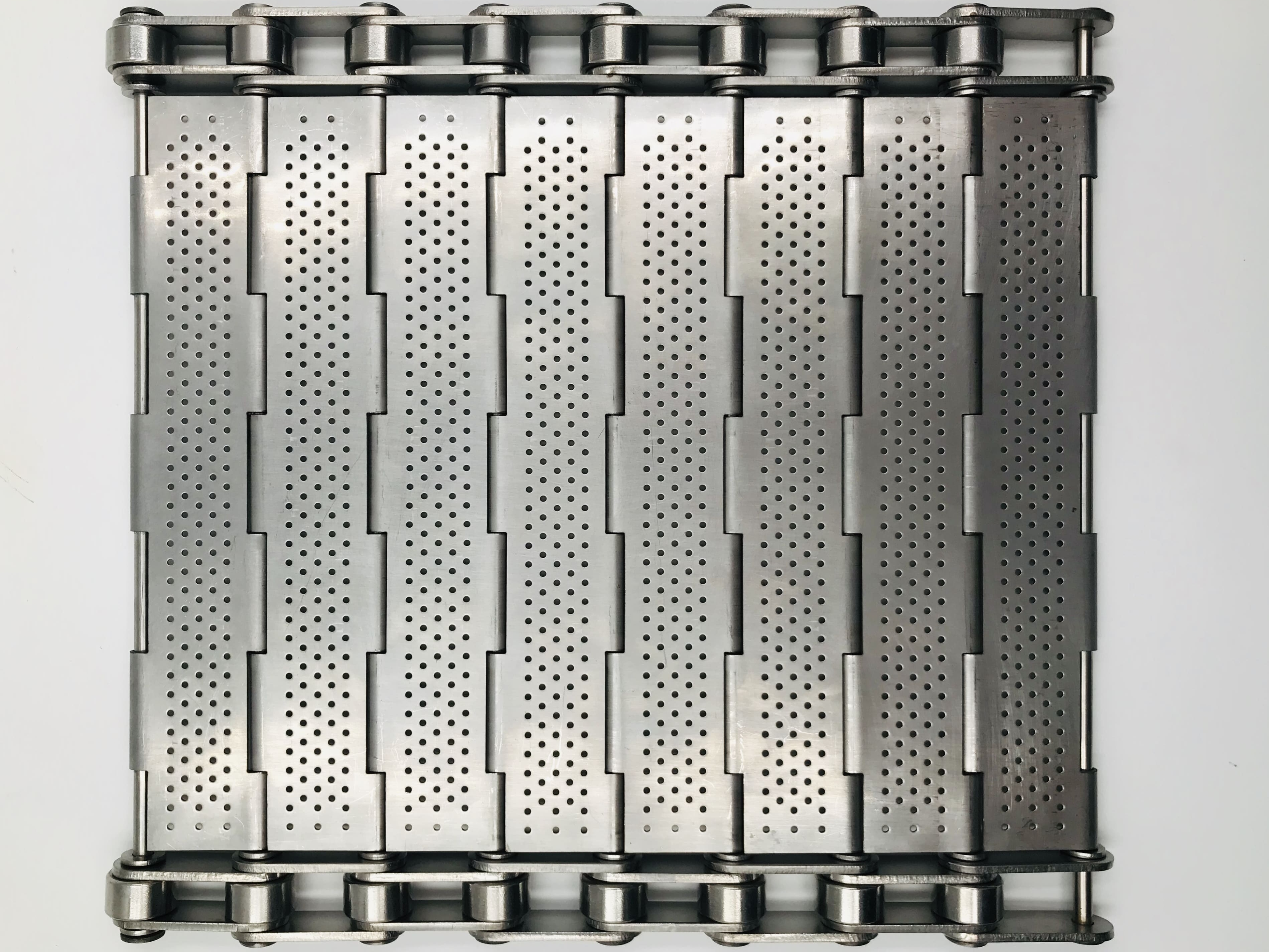 Hinged plate conveyor belt with flat stainless steel carrying surface and side chain drive